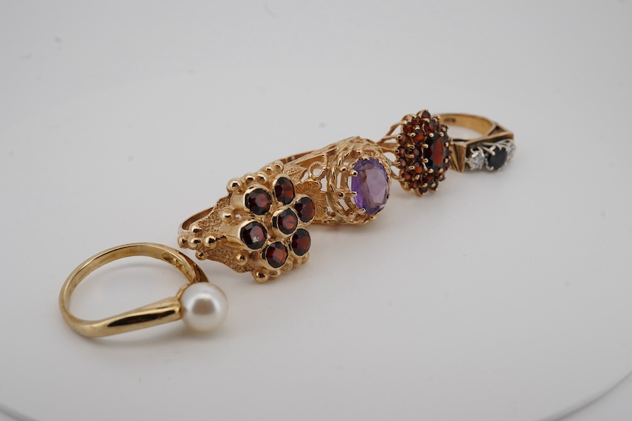 Five assorted modern 9ct gold and gem set rings, including two garner clusters, amethyst and seed pearl, sapphire and diamond chip and single stone cultured pearl, gross weight 20.6 grams. Condition - fair to good